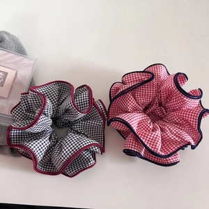 Close-up of checkered oversized hair scrunchies with contrasting piped edges in cotton