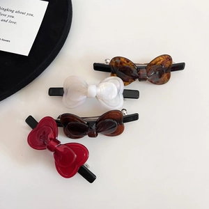 Set of four acetic acid bow hair clips in amber, white, tortoise, and red colors