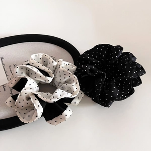 Macro detail of satin polka dot scrunchies showing smooth texture and pleated design