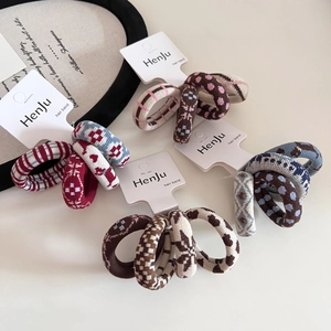 Detailed view of four elastic hair bands with vintage jacquard puppy and dot patterns