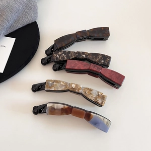 Detail view showing assorted marble texture and tortoise shell acetate banana hair clips