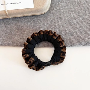 Detail shot of vintage leopard print scrunchie with soft fabric texture and resin buckle