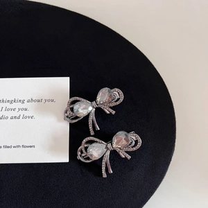 Detailed macro view of gray rhinestone bow hair clips with central teardrop crystal stones