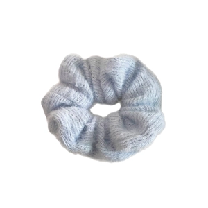 Soft light blue knitted hair scrunchie with elastic fabric texture on white background