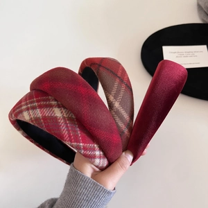 Detail showing four assorted red plaid and velvet padded headbands for a voluminous hair look