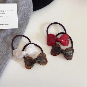 Elegant set of acetate bow hair ties in pearl white, red, tortoise, and brown colors