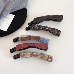 Detail view of cellulose acetate banana hair clips in various elegant marbled patterns