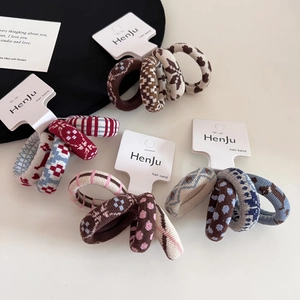 Close-up of four patterned elastic hair bands with polka dots and puppy jacquard designs