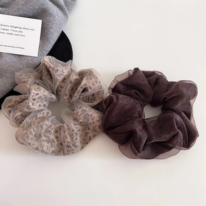 Detail of leopard print and dark brown organza scrunchies set on elegant decor