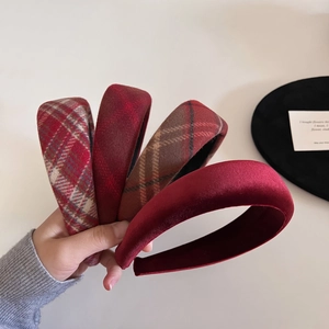 Close-up of vintage red plaid and velvet sponge headbands set for autumn fashion style
