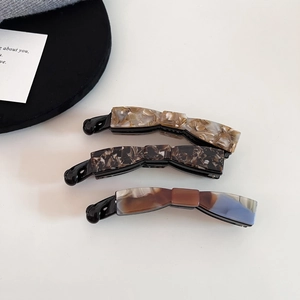 Three acetate bow banana hair clips in amber, tortoiseshell, and grey blue for high ponytails