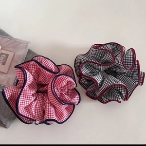 Detailed view of oversized checkered hair scrunchies with contrasting border piping