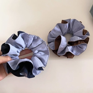 Detail showing two-tone scrunchies with neat stitching in purple, blue, and brown hues