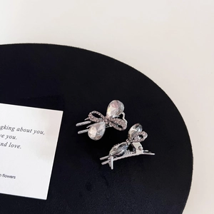Detail view of mini gunmetal hair clips with sparkling rhinestones and crystal bow design
