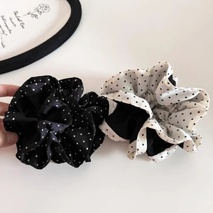 Polka dot satin scrunchies in black and white styles with elegant ruffled textures
