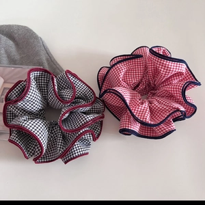 Detail of plaid scrunchies with contrasting trim in black-white and red-white patterns
