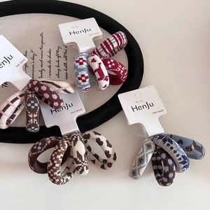 Detailed view of woven jacquard hair ties with heart and geometric patterns in rich tones
