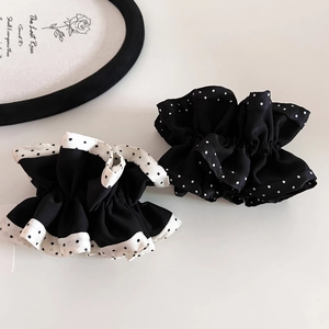 Close-up of elegant satin polka dot hair scrunchies with white and black silk textures