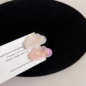 Detailed macro view of cute pearl white and pink cloud-shaped acetate hair clips