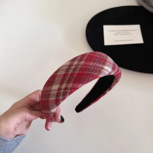 Macro detail of the red plaid padded headband showing the soft wool-like fabric texture