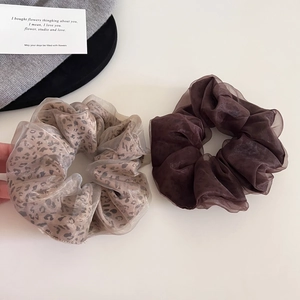 Set of two leopard print and dark coffee brown organza hair scrunchies on white table