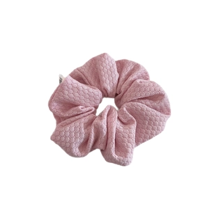 Pink bubble knit oversized scrunchie with honeycomb texture and side label on white background