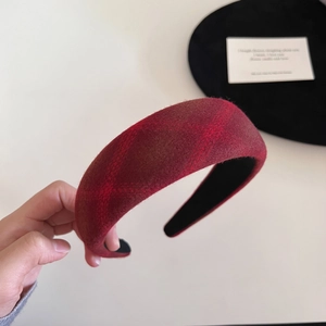 Detail of red plaid sponge headband showing the thick wool fabric texture and retro pattern