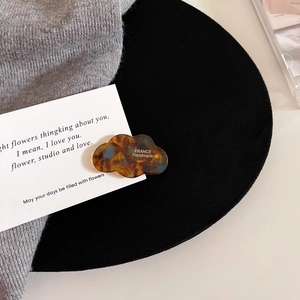 Detailed macro view of cloud-shaped acetate hair clip with vintage tortoiseshell texture