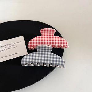 Detail of checkered acetate hair claws in pink and blue for elegant hair styling