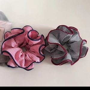 Detail of oversized gingham scrunchies with contrast wave stitched edges and puffy texture