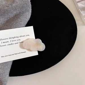 Detail of cloud-shaped acetate hair clip with pink gradient pearl finish and gold lettering