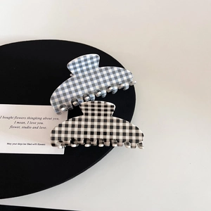 Close-up of checkerboard acetate hair claws in blue and black colors on display