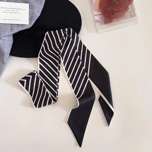 Détail d'un foulard étroit à rayures noires et blanches de style français sur fond doux