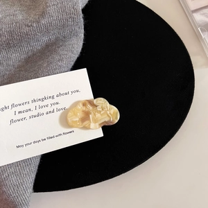 Detailed close-up of a handmade cloud acetate hair clip with marble texture on card