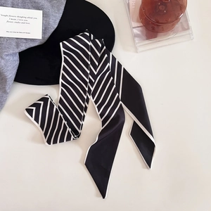 Détail d'un foulard étroit en soie à rayures noires et blanches avec couture de bordure fine
