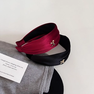 Detailed texture of velvet headbands in red and black with golden bow metal charms