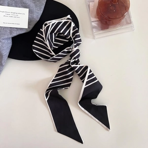 Détail d'un foulard en soie à rayures avec des pointes élégantes et une texture satinée