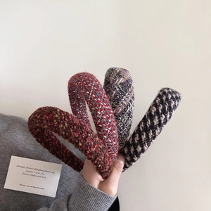 Detail view of four tweed headbands in assorted colors with thick woven textures