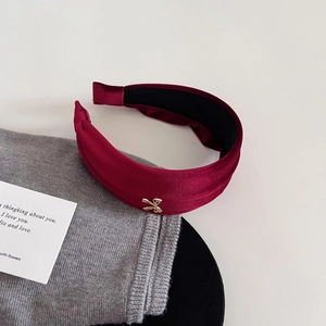 Elegant burgundy velvet headband with gold bow accent for a vintage high skull top look
