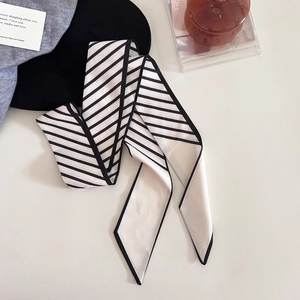 Vue détaillée du foulard en soie rayé avec motifs diagonaux noir et blanc et bordure étroite
