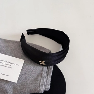 Elegant black velvet headband with gold bow detail, vintage style for high cranial top look