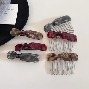 Detail view of acetate bow hair clip set with France Handmade engraving and tortoise texture