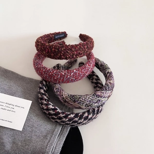 Close-up of four tweed padded headbands with handmade labels in multiple colors