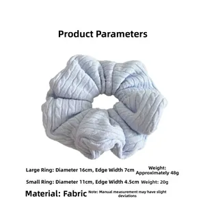 Detail of light blue cable knit hair scrunchies showing large and small size dimensions