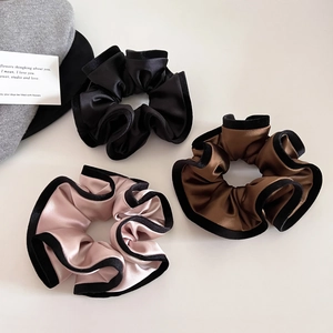 Detailed texture of satin hair scrunchies with elegant velvet edging in multiple colors