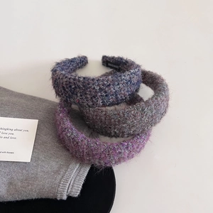 Detailed macro view of textured tweed headbands with handmade label on white background