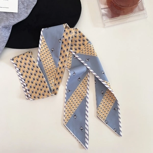 Close-up of vintage paisley and skull print twilly silk scarf with elegant satin texture