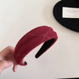 Close-up of thick red plaid wool headband showing soft texture and premium wide design
