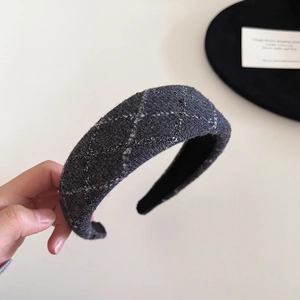 Macro detail of dark grey tweed fabric texture and thick weave on wide headband