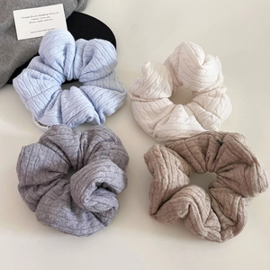 Detail showing knit cable textures and neutral colors of soft scrunchies for hair styling